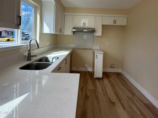 a kitchen with a sink a stove and cabinets