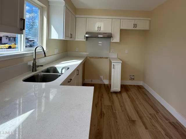 a kitchen with a sink a stove and cabinets