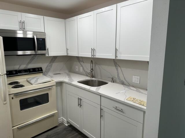273 Suffolk F Boca Raton, FL 33434 - Photo 5 of 9 a kitchen with stainless steel appliances granite countertop a sink and a stove