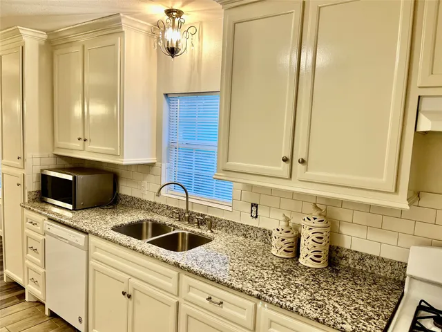 a kitchen with granite countertop a sink and cabinets