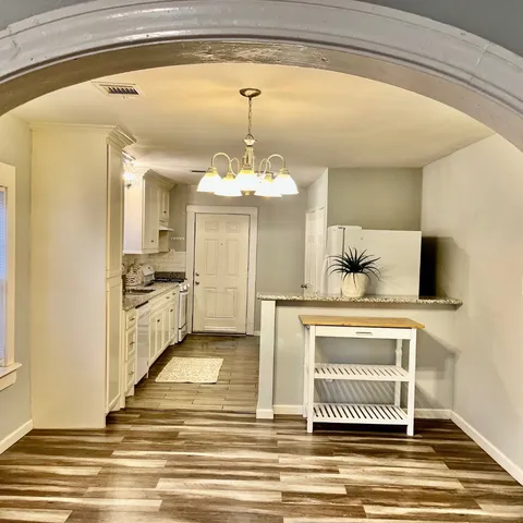 a view of kitchen with stainless steel appliances kitchen island granite countertop a sink and cabinets