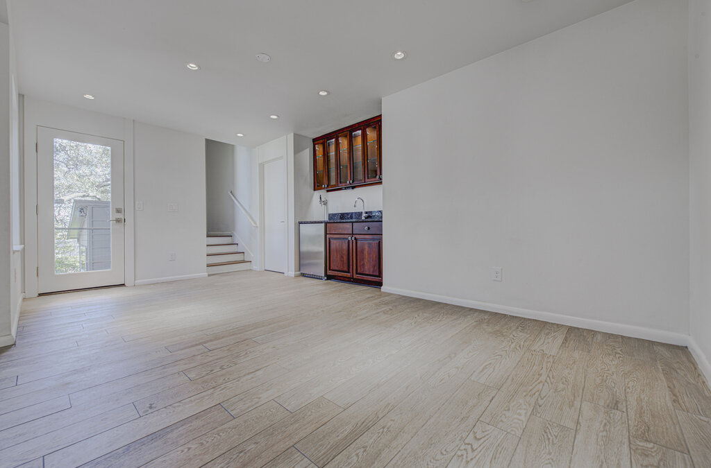 2400 Spring Creek Drive Austin, TX 78704 - Photo 10 of 38 Unfurnished living room featuring recessed lighting, light wood-style flooring, and bar with sink