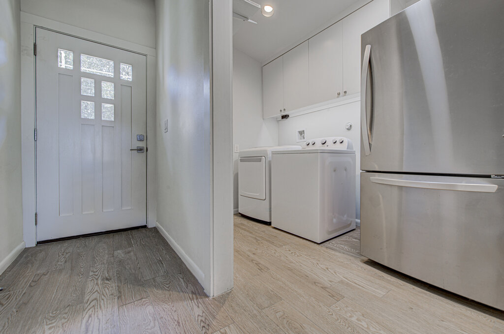 2400 Spring Creek Drive Austin, TX 78704 - Photo 11 of 38 Laundry room with light wood-type flooring, washer and clothes dryer, and cabinet space
