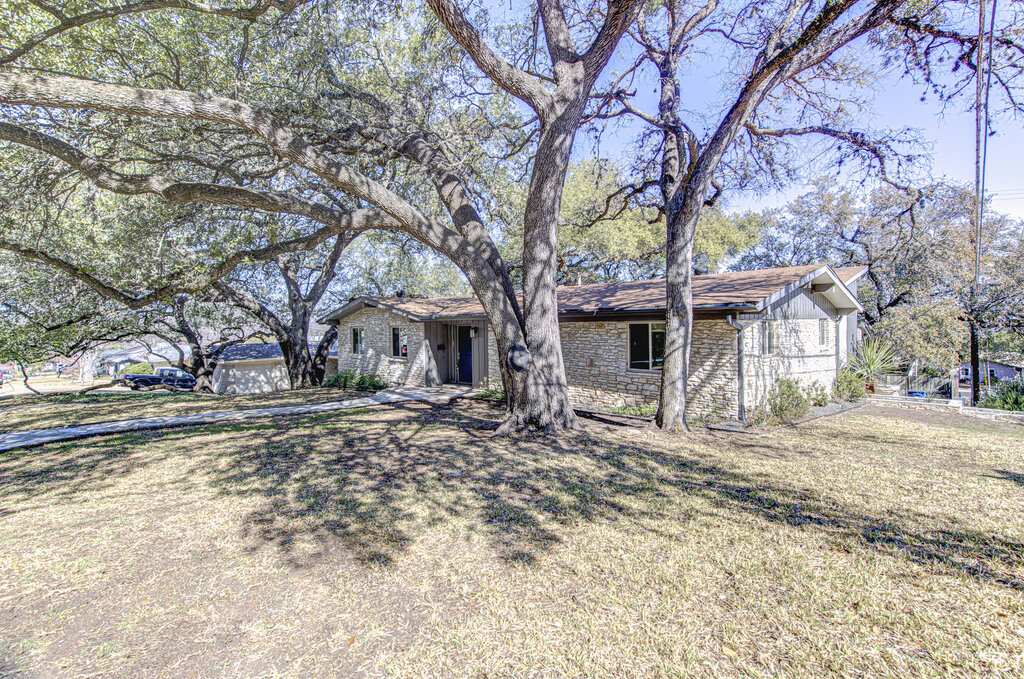 2400 Spring Creek Drive Austin, TX 78704 - Photo 2 of 38 Ranch-style house with stone siding and a front yard