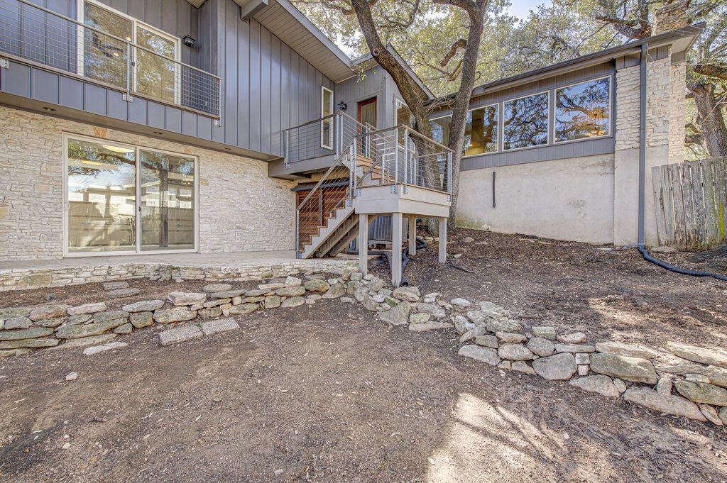 2400 Spring Creek Drive Austin, TX 78704 - Photo 32 of 38 Rear view of property with board and batten siding, a chimney, stone siding, a wooden deck, and a patio area