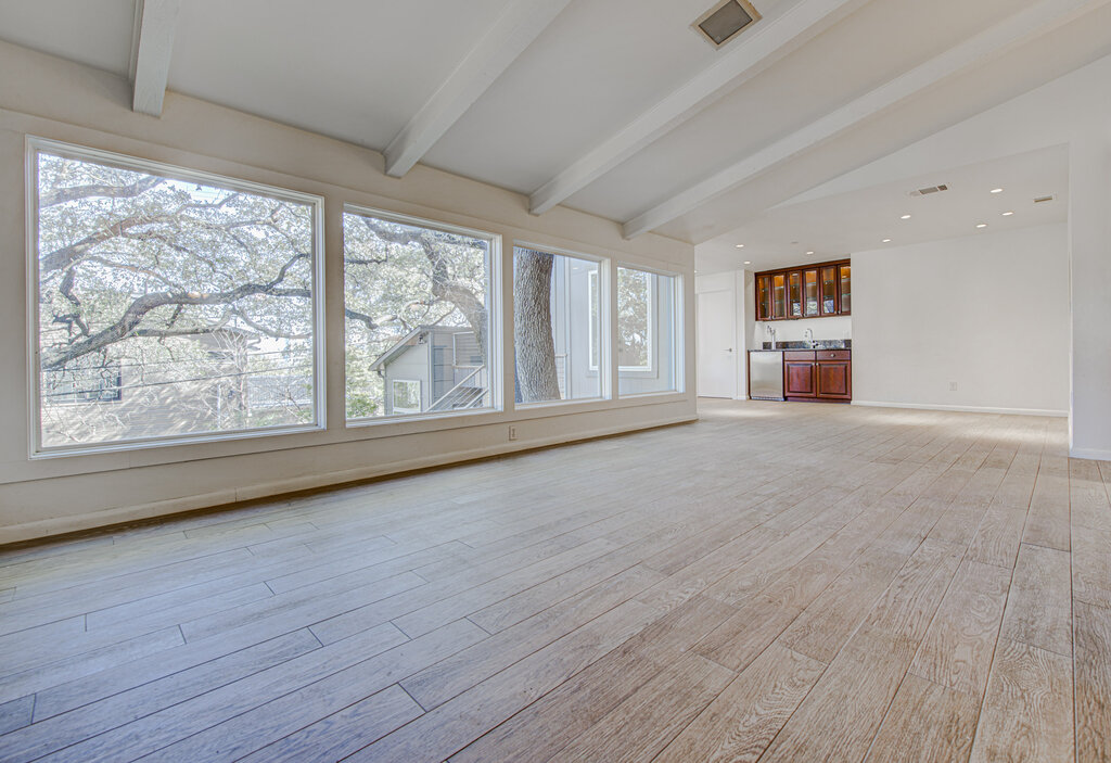 2400 Spring Creek Drive Austin, TX 78704 - Photo 6 of 38 Unfurnished living room with light wood-style floors, lofted ceiling with beams, bar with sink, and recessed lighting