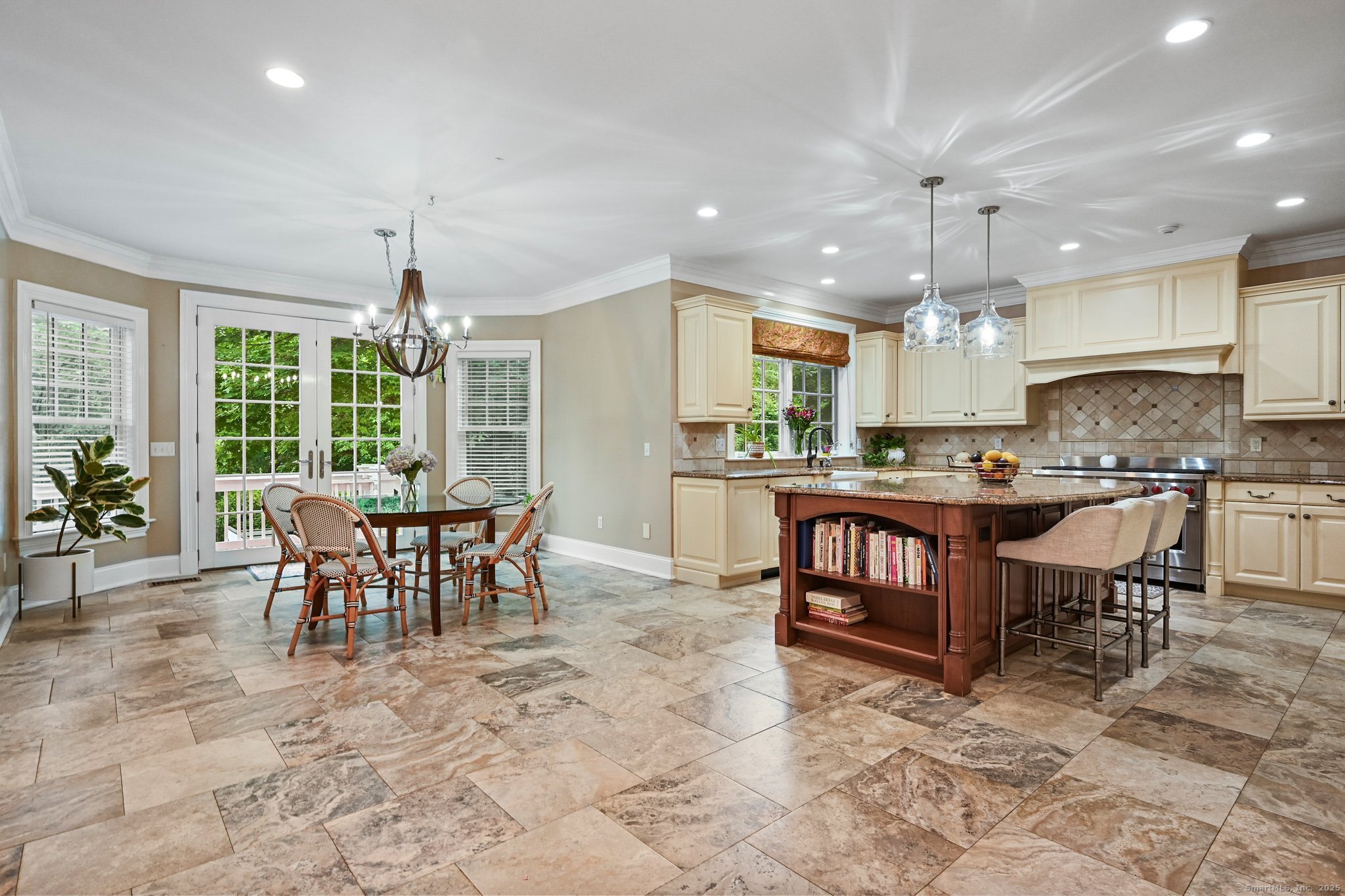 87 Buckingham Ridge Road Wilton, CT 06897 - Photo 19 of 39 a open kitchen view with stainless steel appliances granite countertop a stove a refrigerator a kitchen island a table and chairs