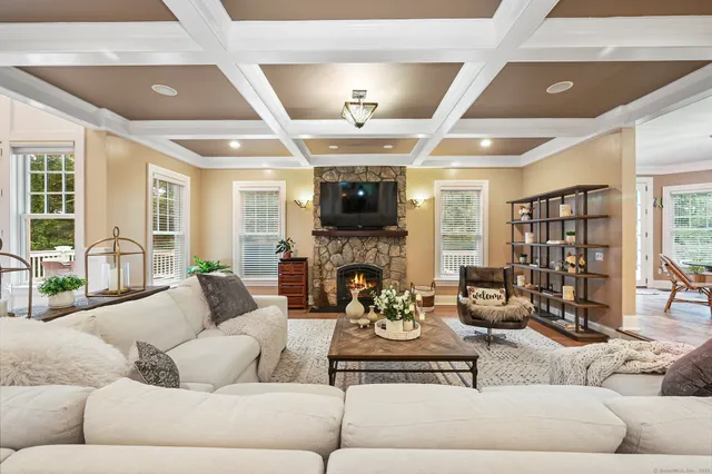 a living room with fireplace furniture and a large window