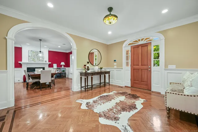 a living room with fireplace furniture and a dining table with wooden floor