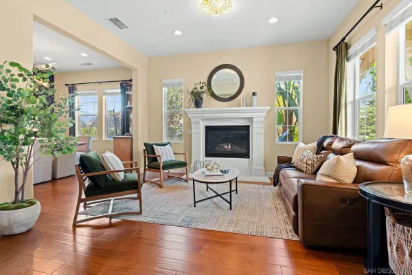 a living room with furniture a wooden floor and a kitchen view