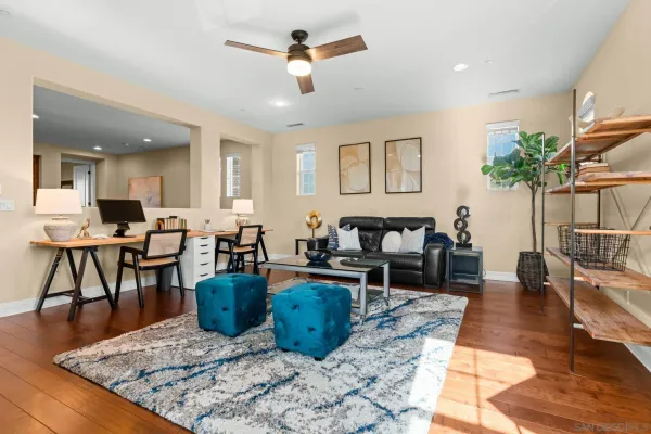 a living room with furniture a flat screen tv and a floor to ceiling window
