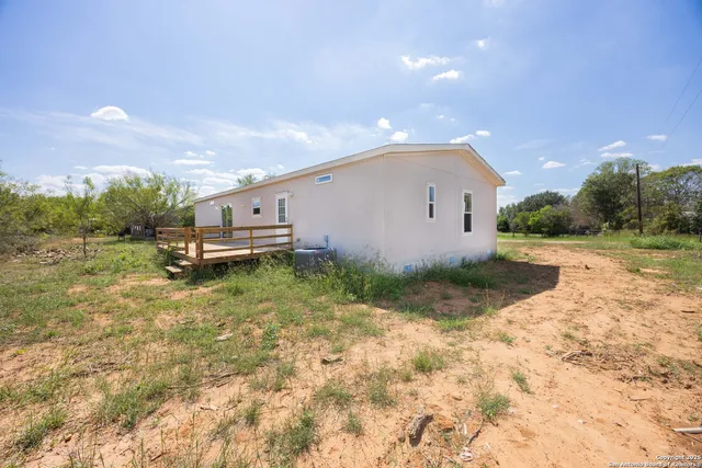 a view of a white house with a yard