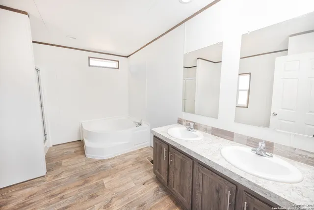 a bathroom with a granite countertop sink a mirror and a bathtub