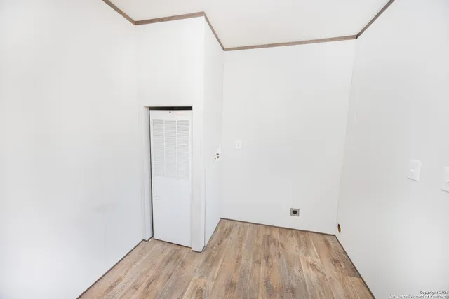 a view of a small space with wooden floor and a window