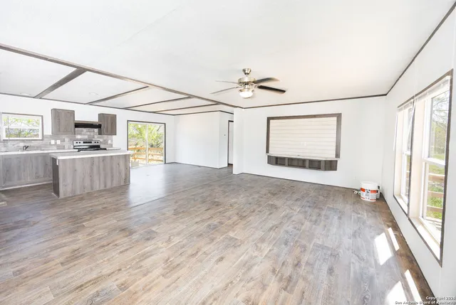 a view of a kitchen with wooden floor and electronic appliances