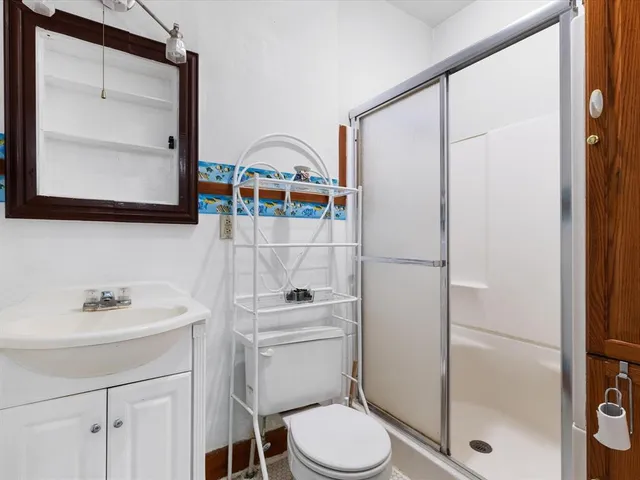 a bathroom with a toilet a sink and a mirror