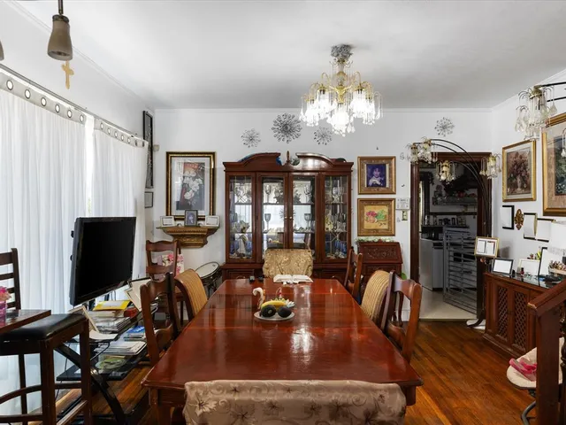 a view of a dining room with furniture a chandelier and wooden floor