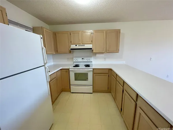 a kitchen with a sink a stove top oven and refrigerator