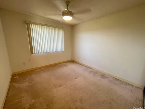 an empty room with windows and fan