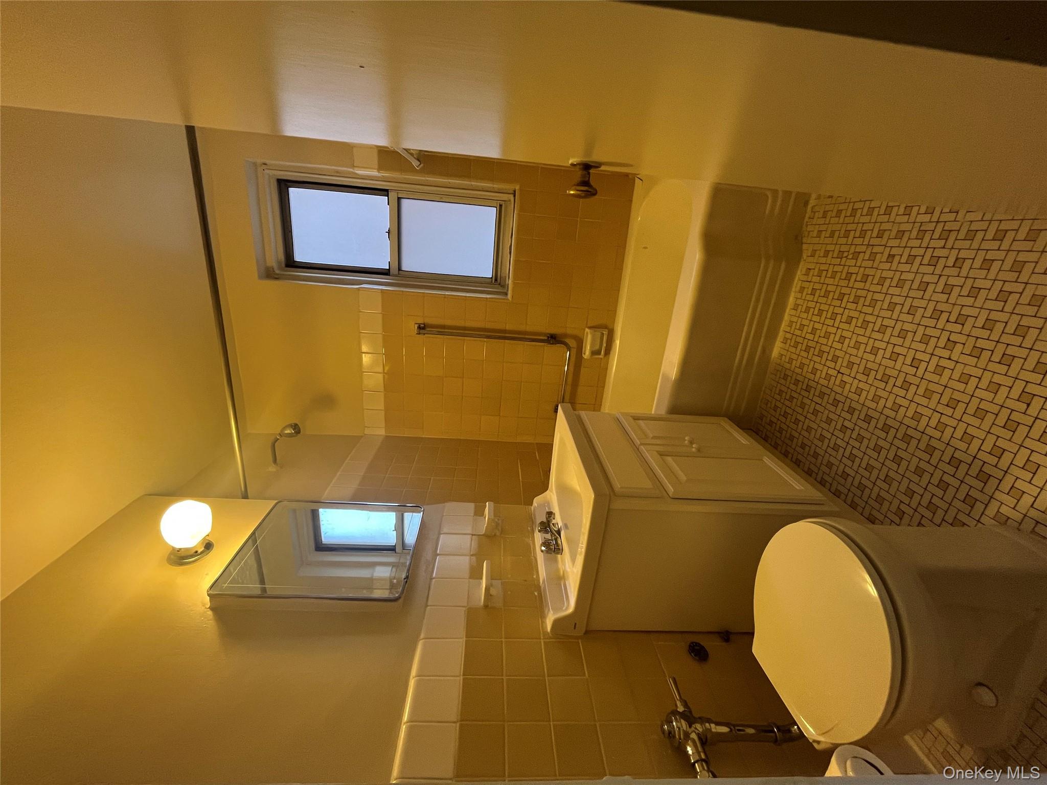 325 East 201st Street, Unit 4D Bronx, NY 10458 - Photo 12 of 22 Bathroom featuring shower / bath combination, vanity, and tile walls