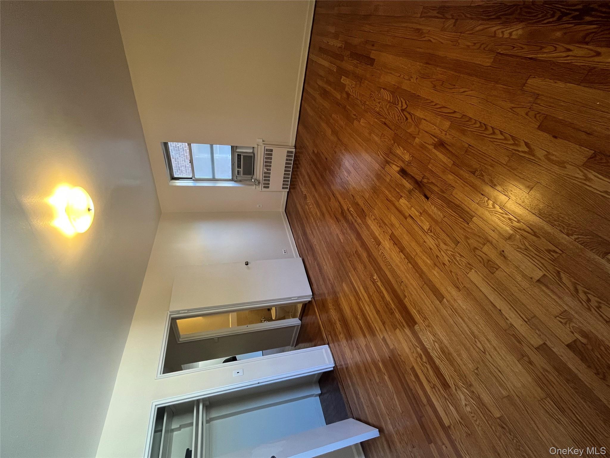 325 East 201st Street, Unit 4D Bronx, NY 10458 - Photo 9 of 22 Unfurnished bedroom featuring radiator, dark wood finished floors, and a closet