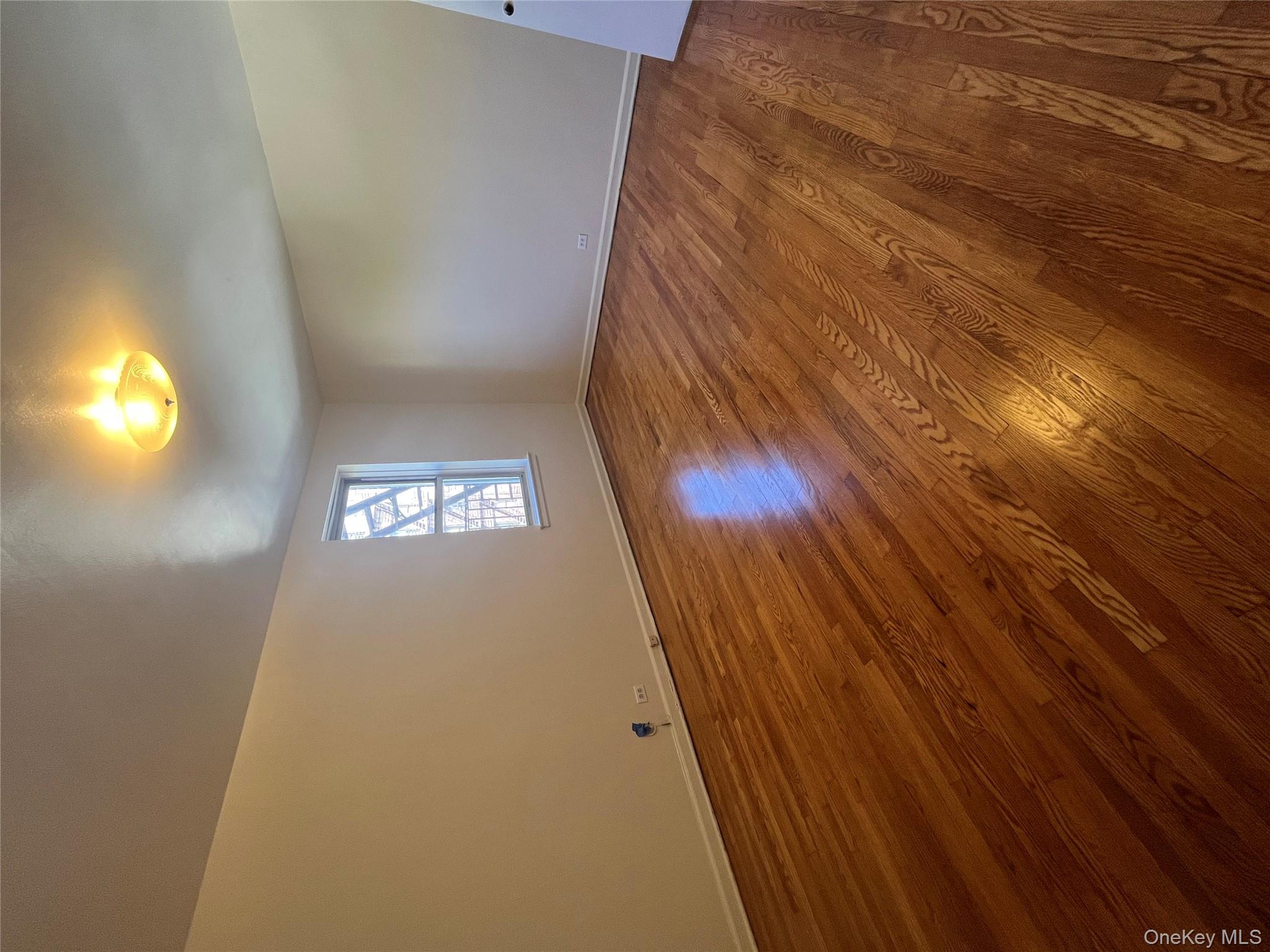 325 East 201st Street, Unit 4D Bronx, NY 10458 - Photo 10 of 22 Unfurnished room featuring wood finished floors and baseboards