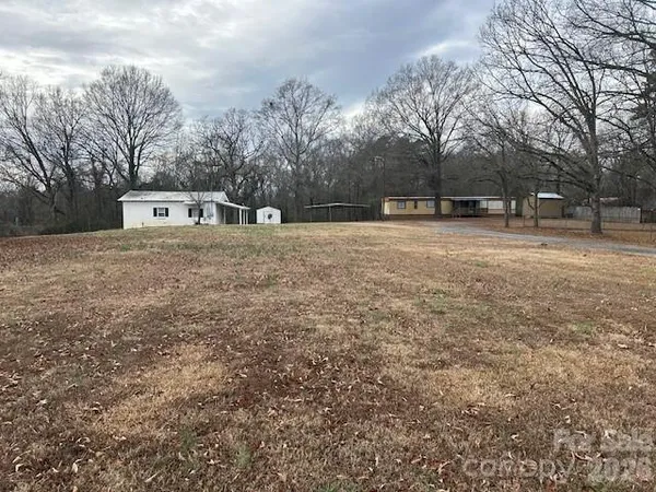 a front view of a house with a yard and trees