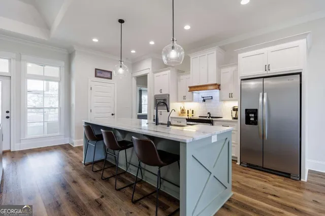 a kitchen with kitchen island a wooden floor and white appliances