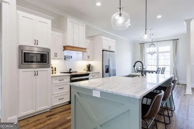 a kitchen with granite countertop a center island a stove cabinets a sink and a refrigerator