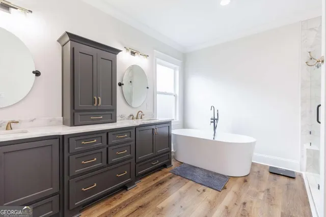 a spacious bathroom with a double vanity sink mirror and bathtub