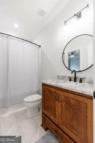 a bathroom with a toilet a sink and mirror