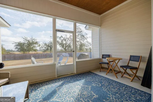 a backyard of a house with wooden floor and outdoor seating