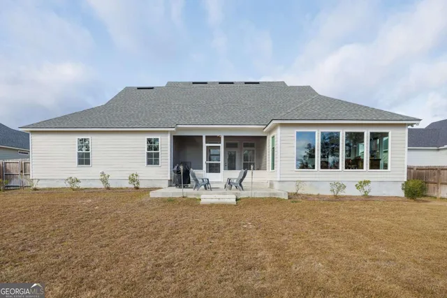 a view of a large house with a big yard and large trees