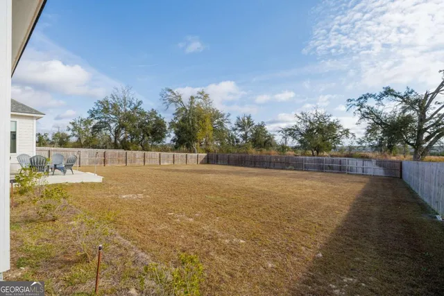 a front view of house with yard and trees in the background