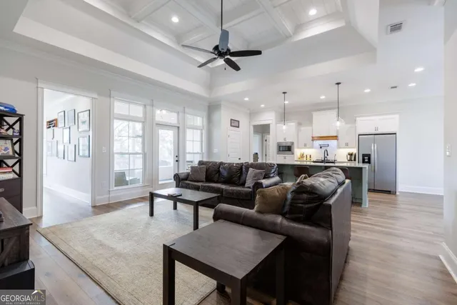 a living room with furniture kitchen view and a large window