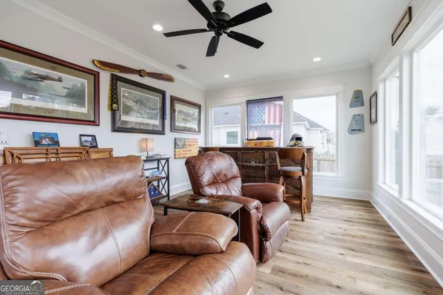 a living room with furniture a ceiling fan and a window