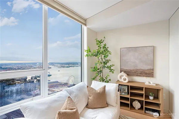 a living room with furniture potted plant and a large window
