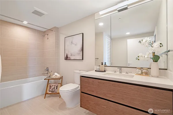 a bathroom with a granite countertop sink a toilet and bathtub