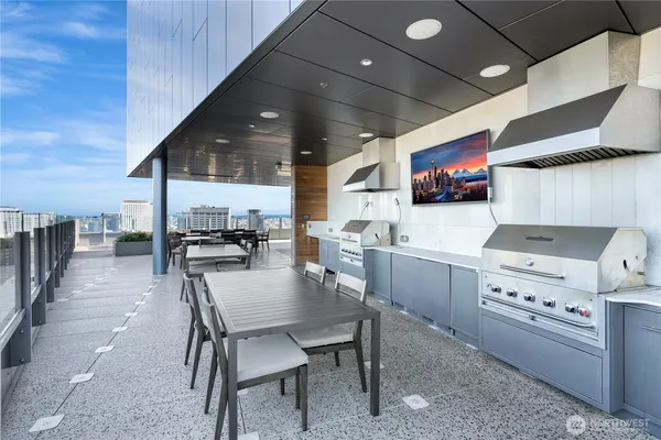 a kitchen with stainless steel appliances kitchen island granite countertop a sink a stove a refrigerator cabinets and chairs