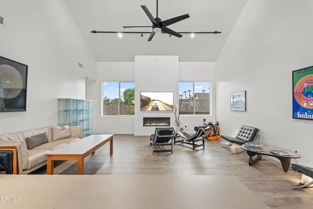 a living room with furniture gym equipment and a view of kitchen
