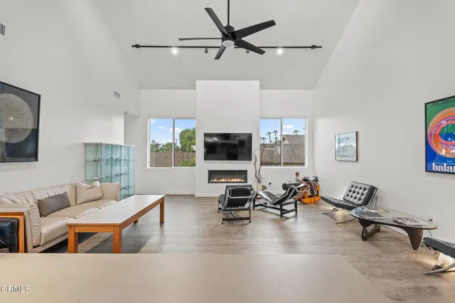 a living room with furniture kitchen view and a flat screen tv