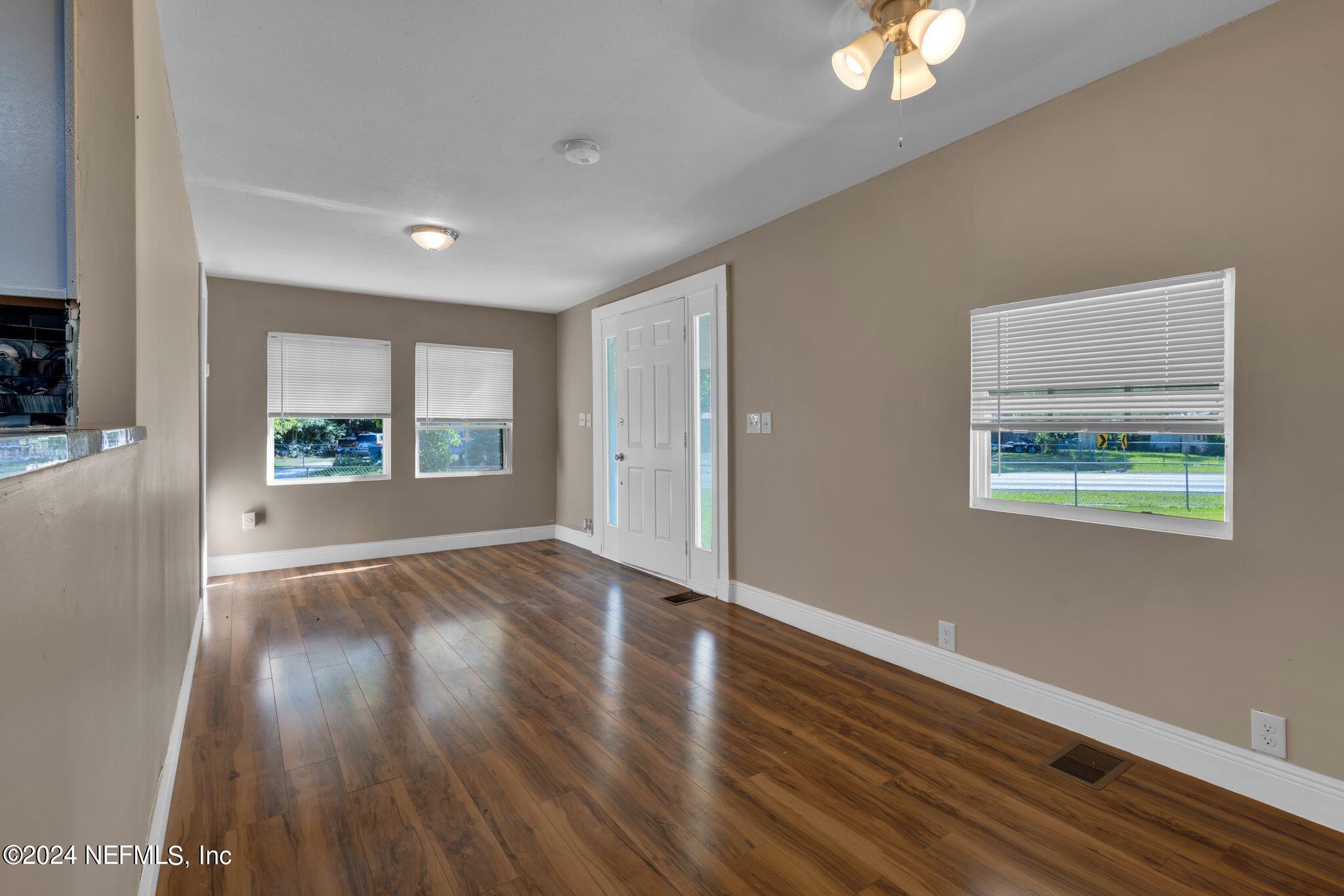 10357 Anson Road Jacksonville, FL 32246 - Photo 12 of 27 a view of an empty room with wooden floor and a window