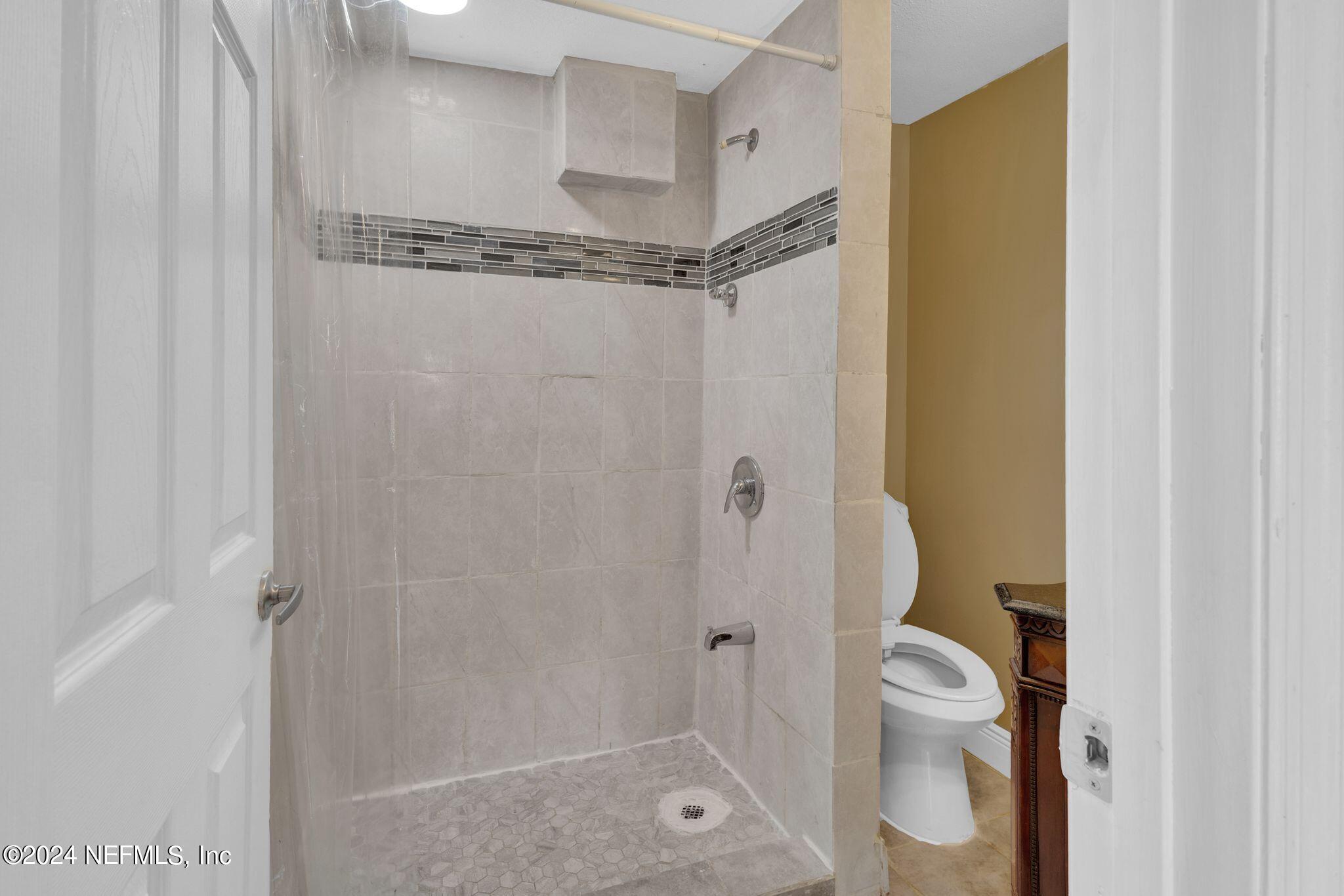 10357 Anson Road Jacksonville, FL 32246 - Photo 14 of 27 a bathroom with a shower a toilet and a sink