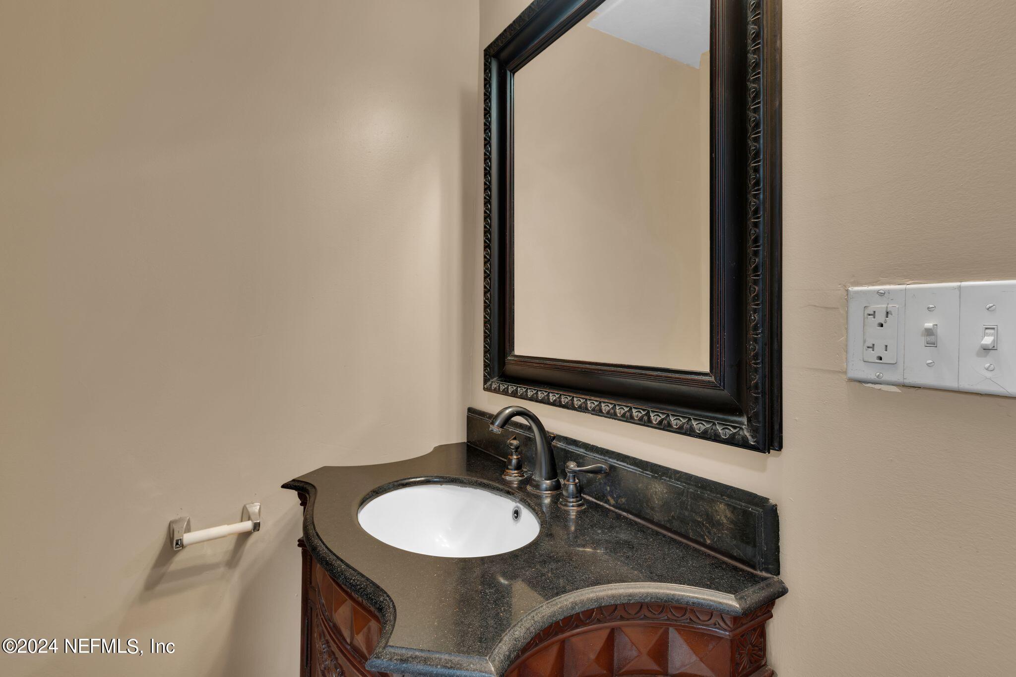 10357 Anson Road Jacksonville, FL 32246 - Photo 16 of 27 a bathroom with a granite countertop sink and a mirror