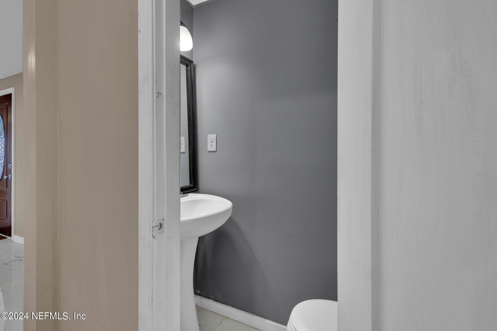 10357 Anson Road Jacksonville, FL 32246 - Photo 24 of 27 a bathroom with a sink and a mirror