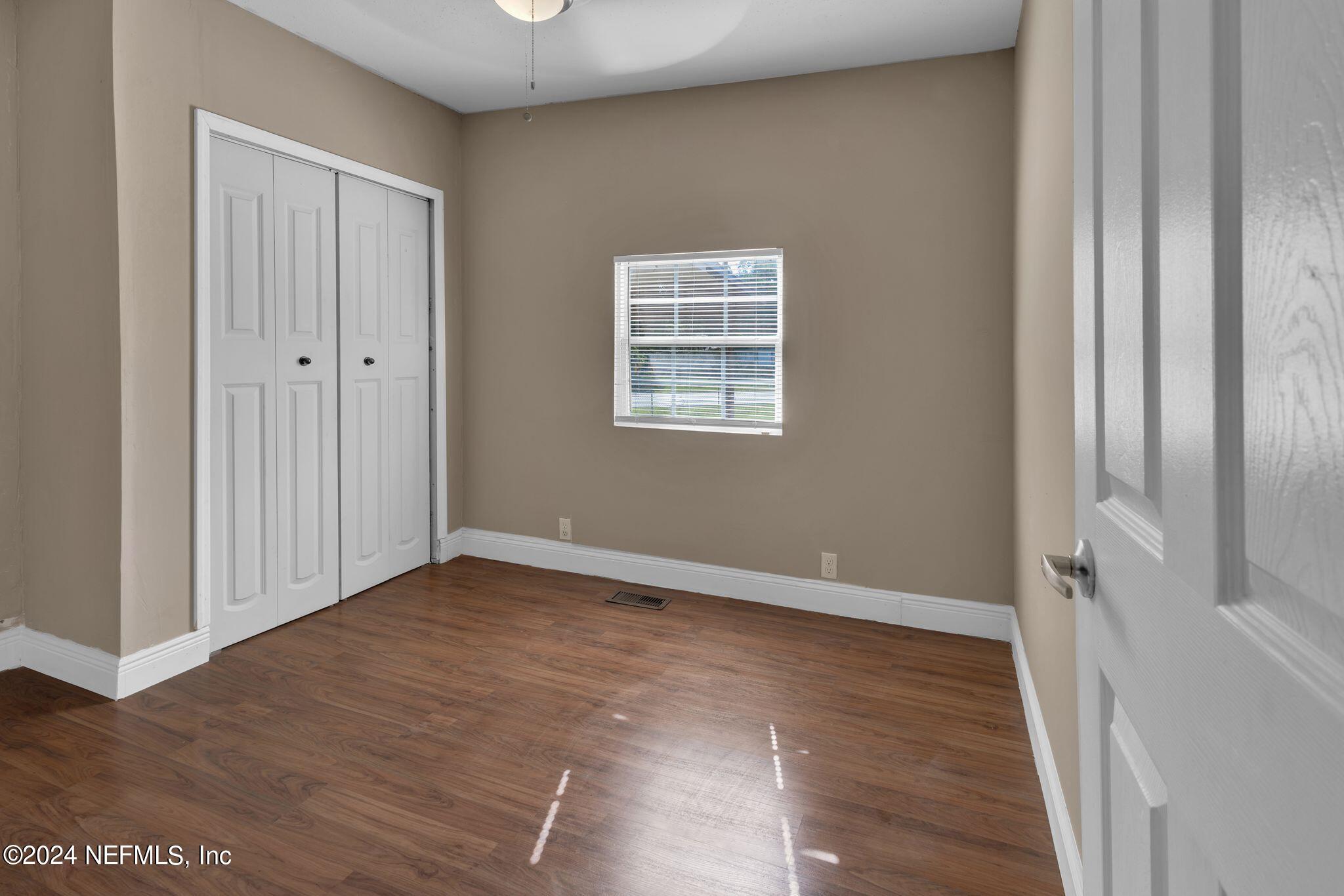 10357 Anson Road Jacksonville, FL 32246 - Photo 9 of 27 a view of an empty room with wooden floor and a window
