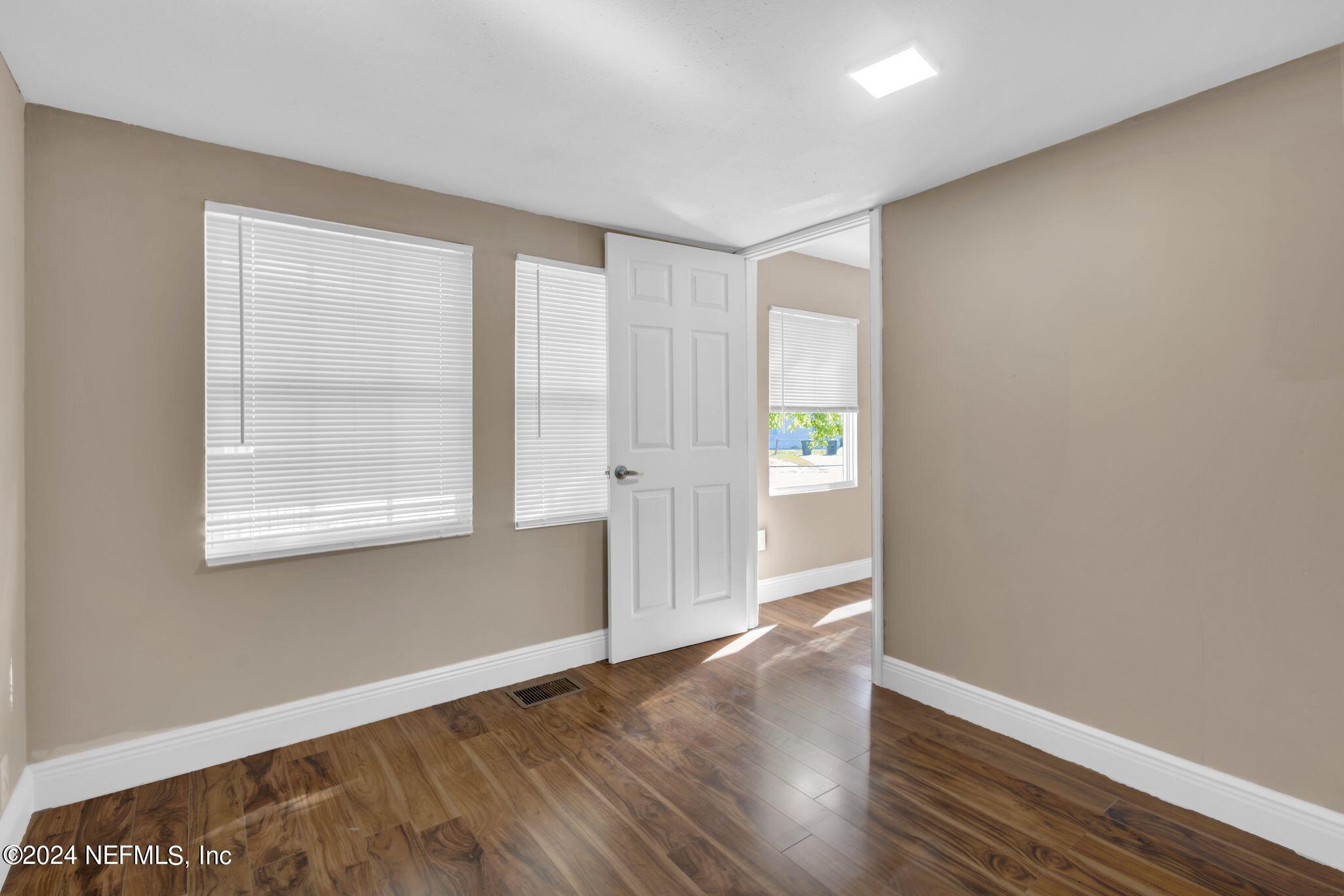 10357 Anson Road Jacksonville, FL 32246 - Photo 10 of 27 an empty room with wooden floor and windows