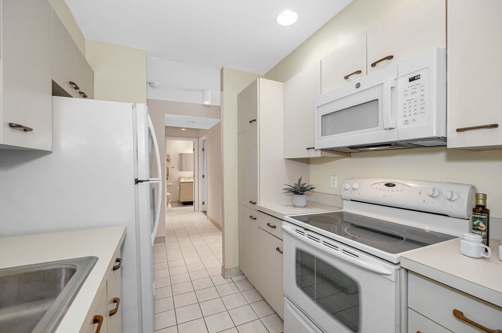 4 Summit Drive, Unit 413 Reading, MA 01867 - Photo 11 of 20 a kitchen with a sink stove and refrigerator