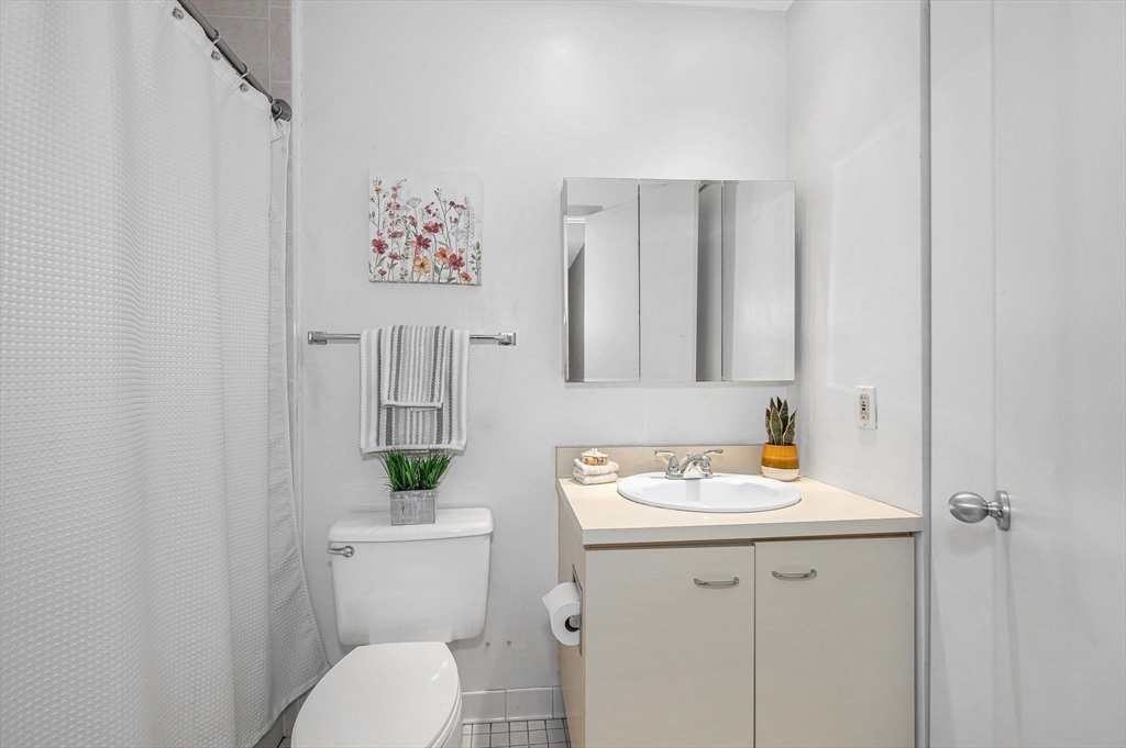 4 Summit Drive, Unit 413 Reading, MA 01867 - Photo 12 of 20 a bathroom with a toilet sink and mirror