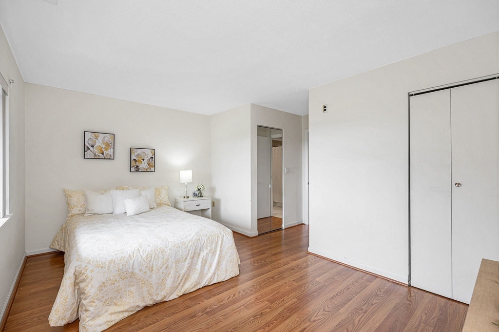 4 Summit Drive, Unit 413 Reading, MA 01867 - Photo 13 of 20 a bedroom with a large bed and wooden floor